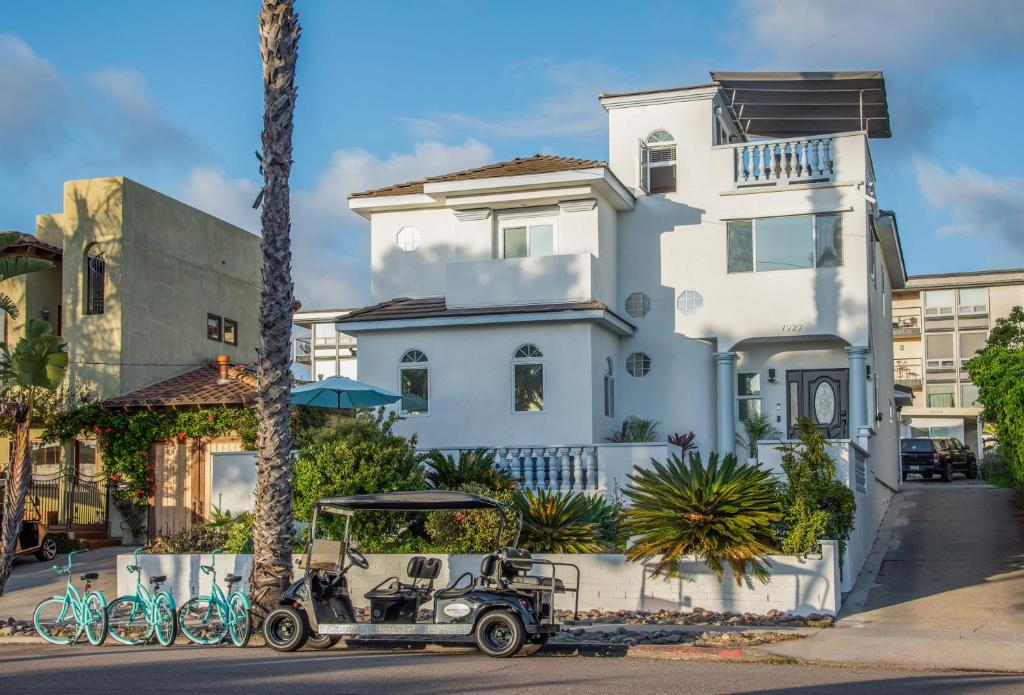 um carrinho de golfe estacionado em frente a uma casa branca em Coastal-Inspired Home near Beach & Village em San Diego