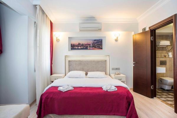 - une chambre avec un grand lit et une couverture rouge dans l'établissement NACRE RESIDENCE, à Istanbul