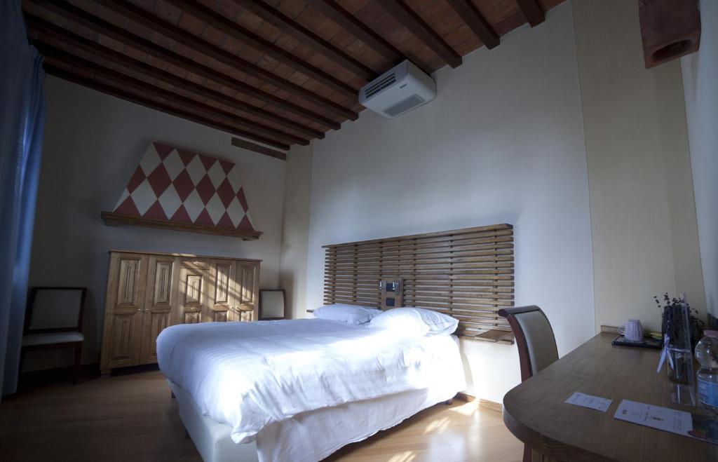 Agriturismo Cascina Farisengo في Stagno Lombardo: غرفة نوم بسرير ابيض كبير وطاولة