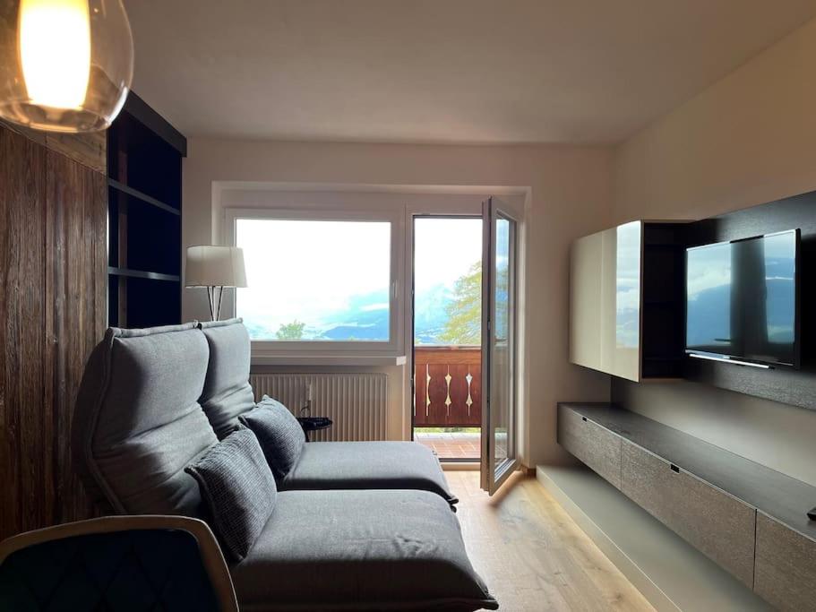ein Wohnzimmer mit einem Sofa und einem Flachbild-TV in der Unterkunft Appartement Inntalblick in Pill
