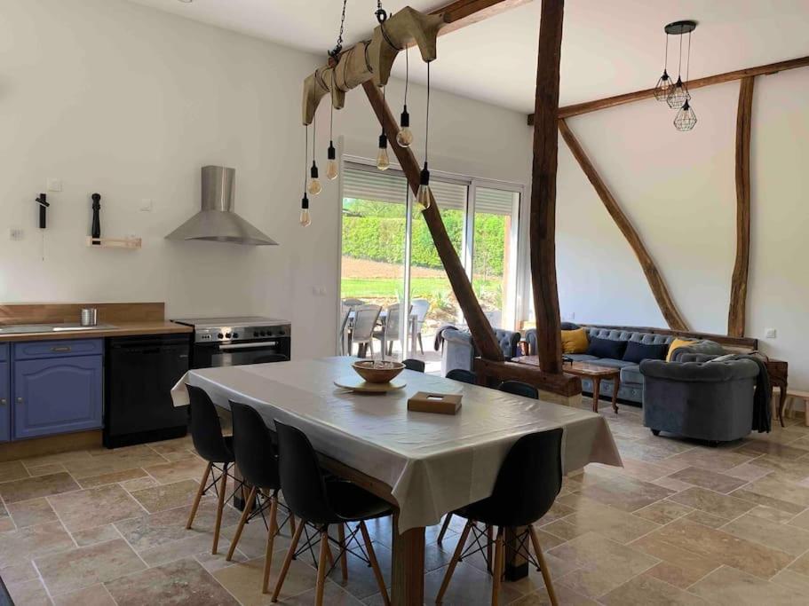 eine Küche und ein Wohnzimmer mit einem Tisch und Stühlen in der Unterkunft Gîte La Grange, Maison entière in Blicourt