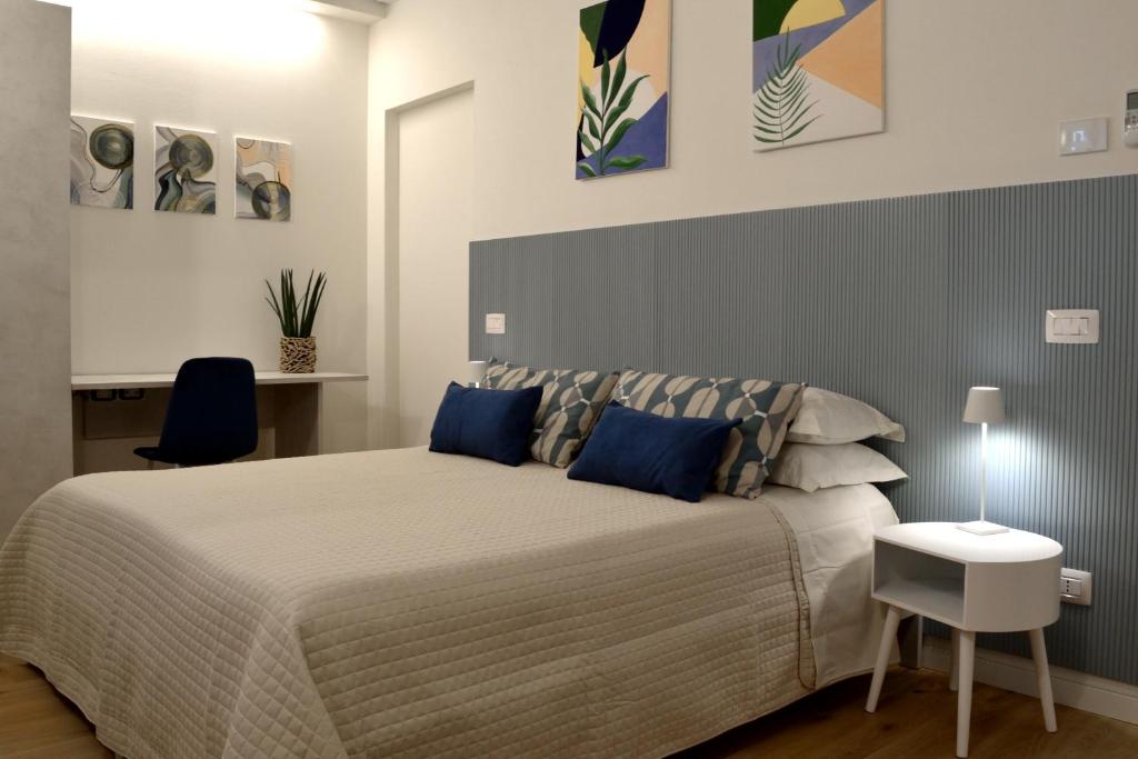 een slaapkamer met een groot bed met blauwe kussens bij B&B Case Bianche in Maranello