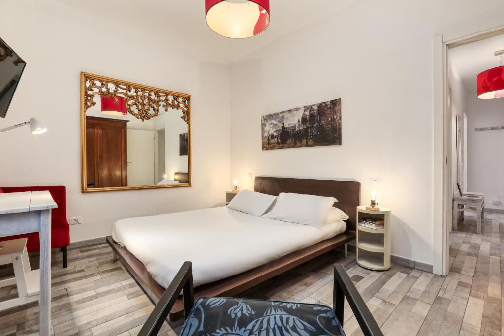 1 dormitorio con cama, espejo y mesa en ANGOLO ALLA STAZIONE - Bilocale ristrutturato zona stazione e ospedali, en Pavia
