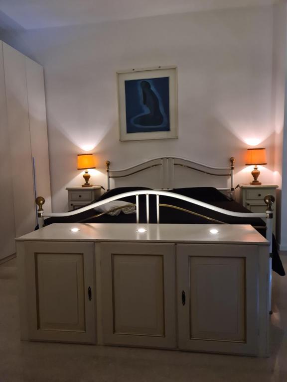 ein Schlafzimmer mit einem Bett mit einem Tisch und 2 Lampen in der Unterkunft Tiny Apartment Vitty - San Martino Buon Albergo Verona in San Martino Buon Albergo