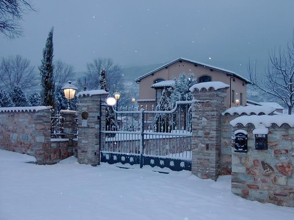 Una cerca frente a una casa con nieve. en Residenza Le Querce Bilocale, en Fossato di Vico