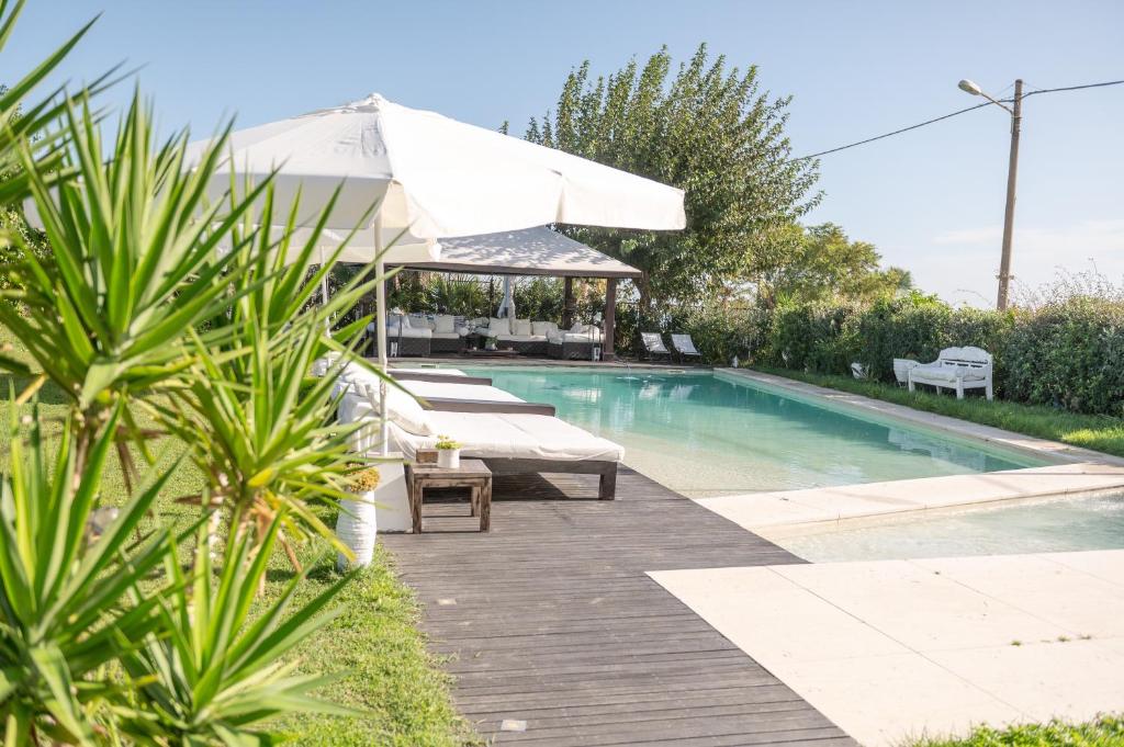 a swimming pool with a patio and an umbrella at Villa VERNEY in Albisola Superiore