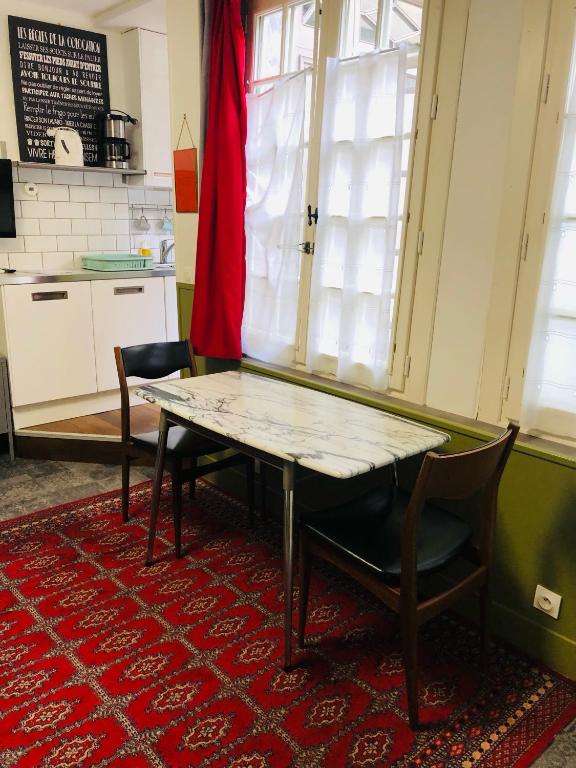- une table et des chaises dans une pièce avec cuisine dans l'établissement PAPILLONS De Nuit Champagne Troyes, à Troyes