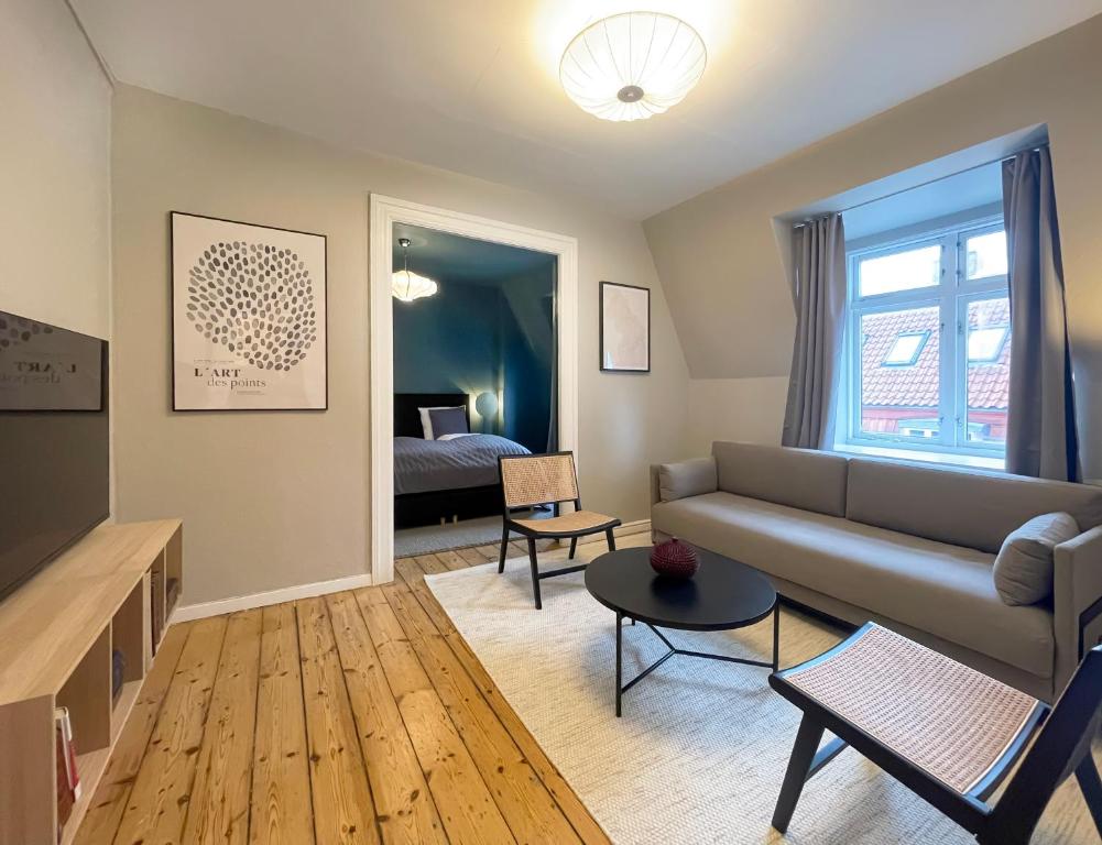 een woonkamer met een bank en een bed bij Rustic & Cozy 2BR in Heart of CPH City by Strøget in Kopenhagen