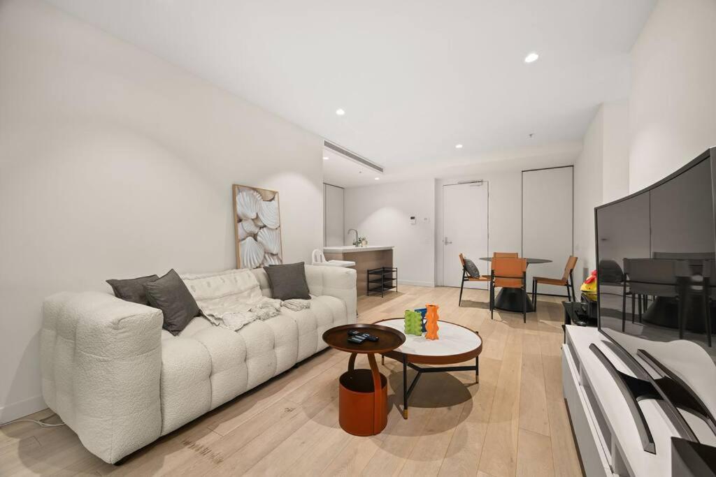 een woonkamer met een witte bank en een tafel bij Level 59 Delightful City Central 3B2B1C Apartment in Melbourne