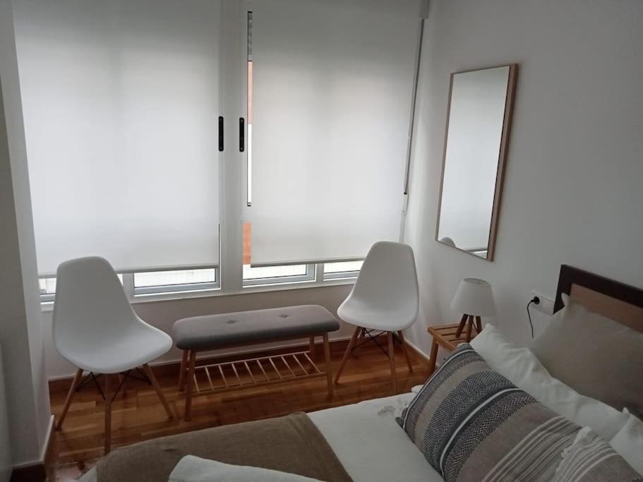 1 dormitorio con 1 cama, 2 sillas y ventana en Apartamento céntrico en Vigo en Vigo