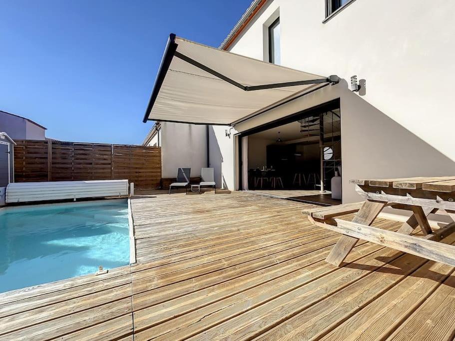 a deck with a swimming pool and a patio umbrella at 3102-Villa 6 couchages avec piscine in Elne
