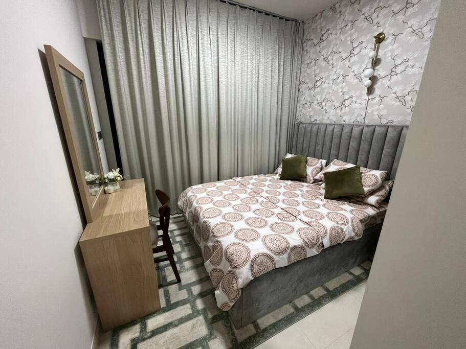 a bedroom with a bed and a table with a mirror at 1BHK smart home - Downtown Dubai in Dubai
