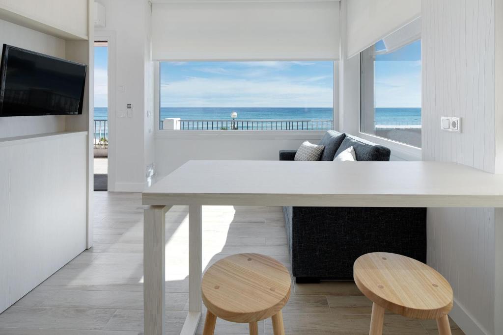 una sala de estar blanca con vistas al océano en Apartamentos Egona Zarautz sobre el mar, en Zarautz