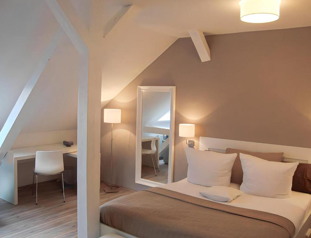 Schlafzimmer mit einem Bett mit einem Spiegel und einem Tisch in der Unterkunft Apartment Hotel Lindeneck in Erfurt