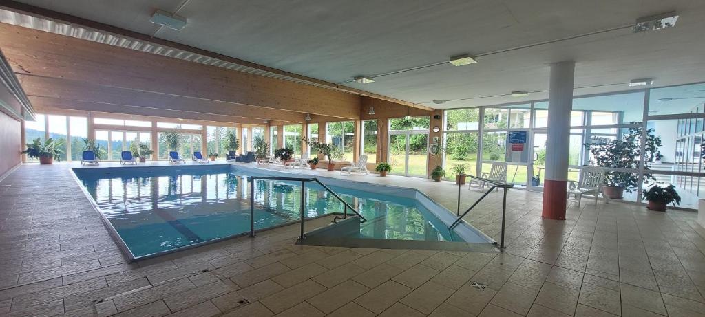 a large swimming pool in a building with glassdoors at Anna Altreichenau in Neureichenau