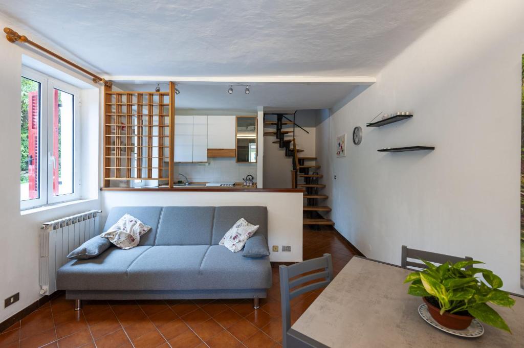 - un salon avec un canapé bleu et une table dans l'établissement Ca' da Lalla by Wonderful Italy, à Varazze