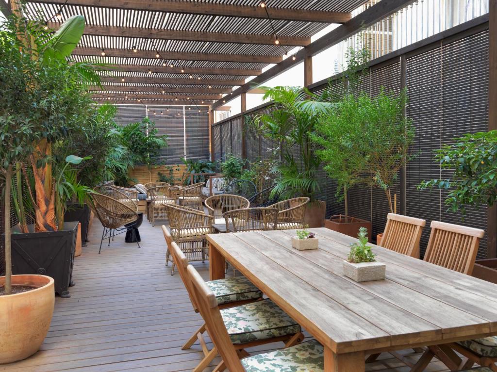 a patio with a wooden table and chairs and plants at Boutique Hotel H10 Catalunya Plaza in Barcelona