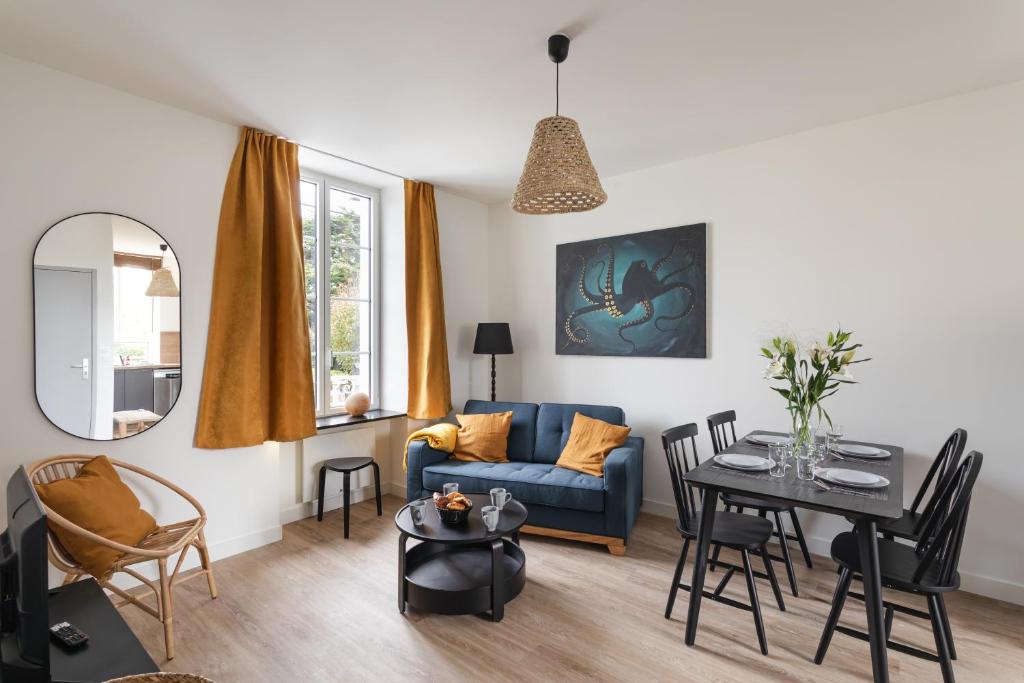 un salon avec un canapé bleu et une table dans l'établissement Le Poulpe - Proche plage de Rochebonne, à Saint-Malo