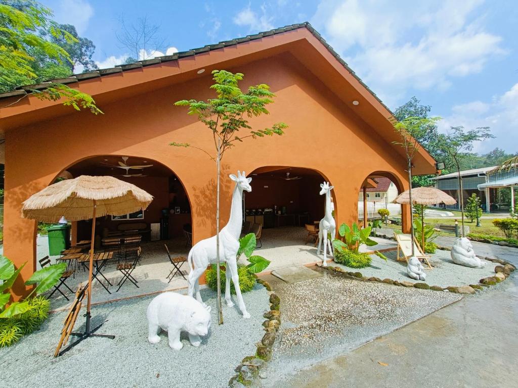 una casa con estatuas de animales delante de ella en LiLLA Rainforest Retreats by Swing & Pillows, en Hulu Langat