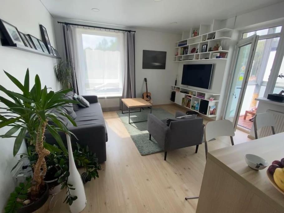 uma sala de estar com um sofá e uma mesa em City Park Apartment em Vilnius