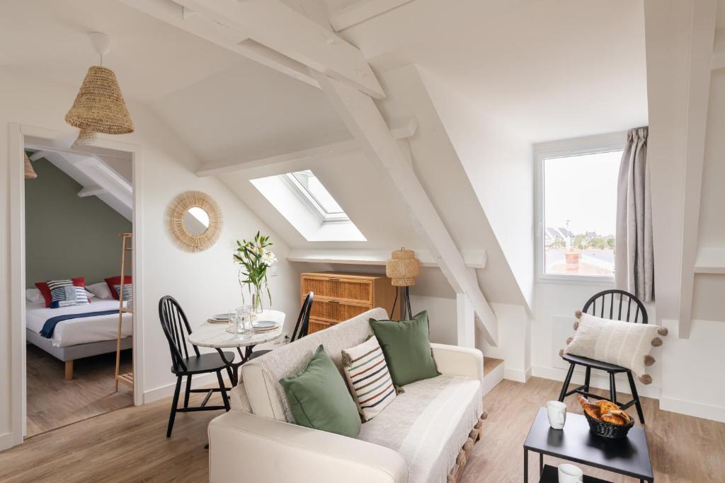 ein Wohnzimmer mit einem Sofa und einem Tisch in der Unterkunft Force 9 - Proche plage de Rochebonne in Saint-Malo
