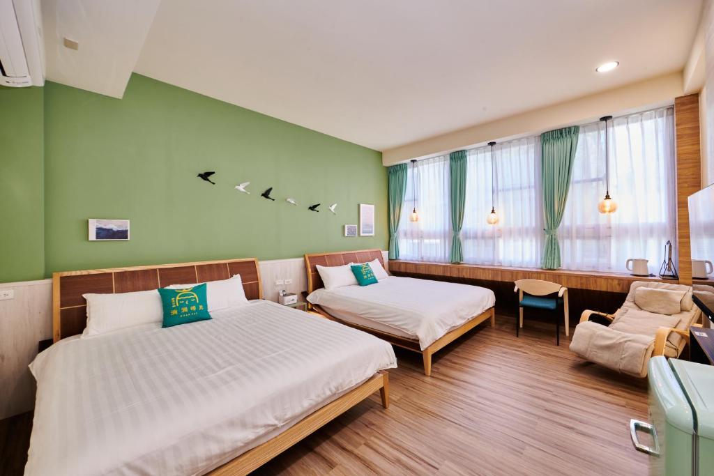 a hotel room with two beds and a couch at Warmday Homestel in Chiayi City