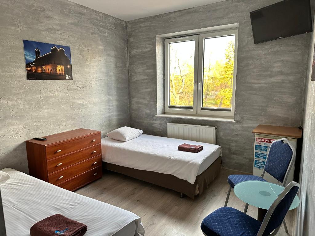 een kleine slaapkamer met 2 bedden en een raam bij Hostel Radom in Radom