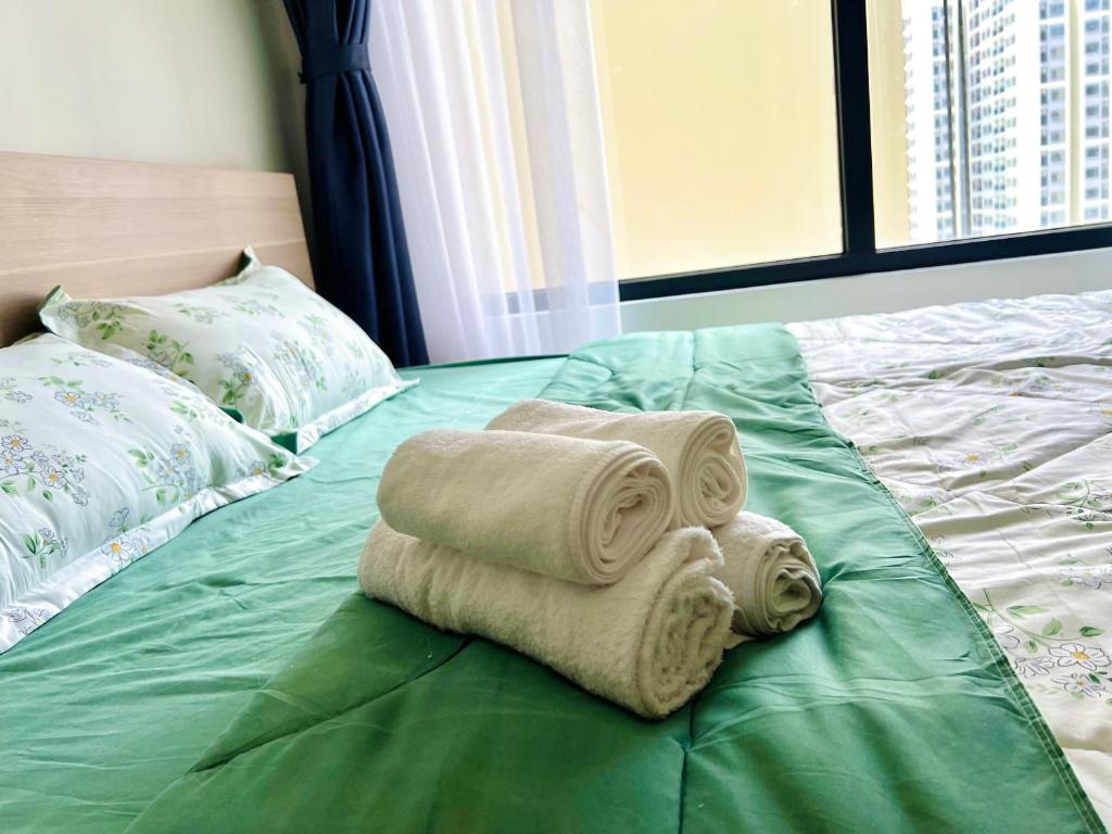 ein Bett mit zwei Handtüchern darüber in der Unterkunft Vin Grand Park - TP. Thủ Đức in Tân Vạn