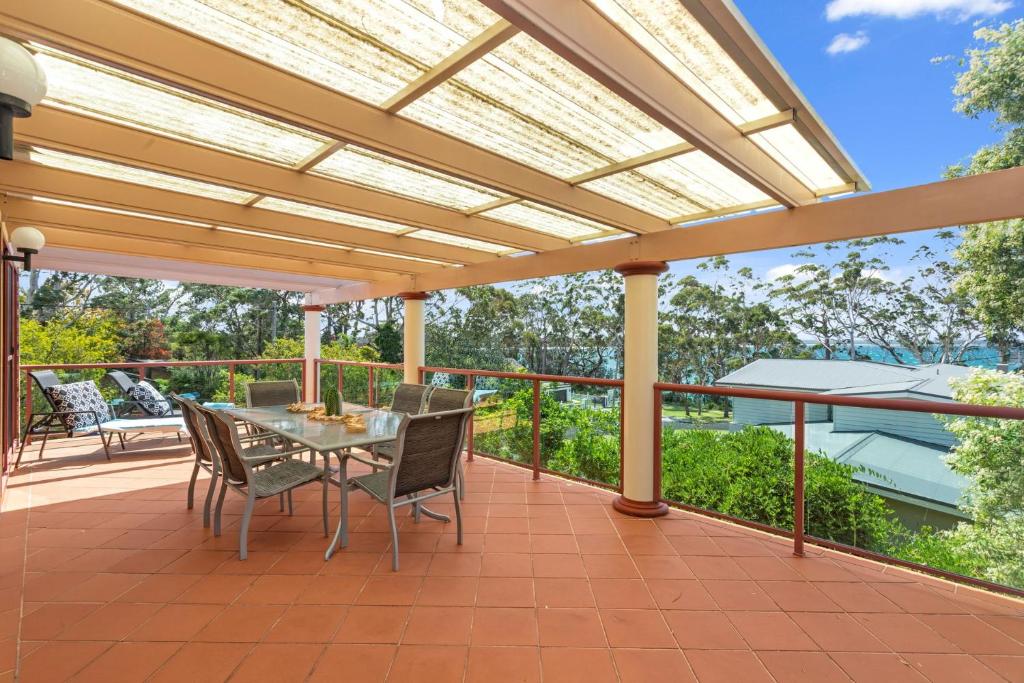 a patio with a table and chairs on a deck at Orion Beach Retreat in Vincentia