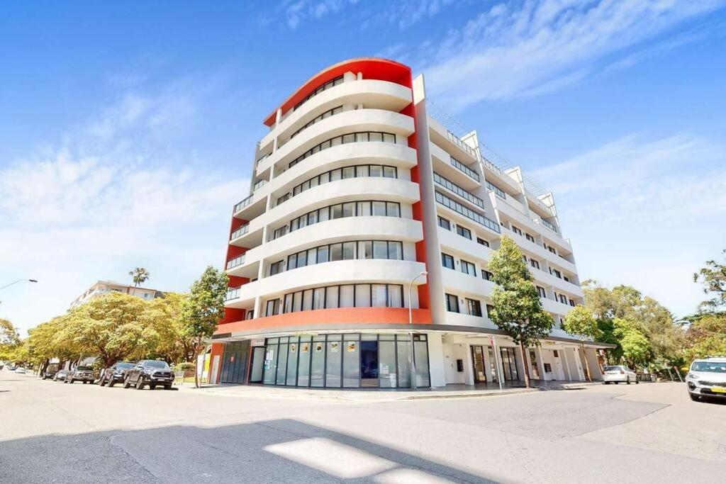 a red and white building with cars parked in front of it at 2Bedrooms 2Bathrooms Oasis in Parramatta w parking in Sydney