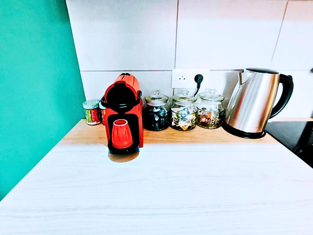 una encimera con jarras y una cafetera. en Le Cocon, en Toulon