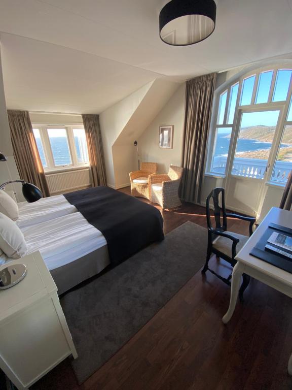 a bedroom with a large bed and a desk with a laptop at Grand Hôtel Mölle in Mölle