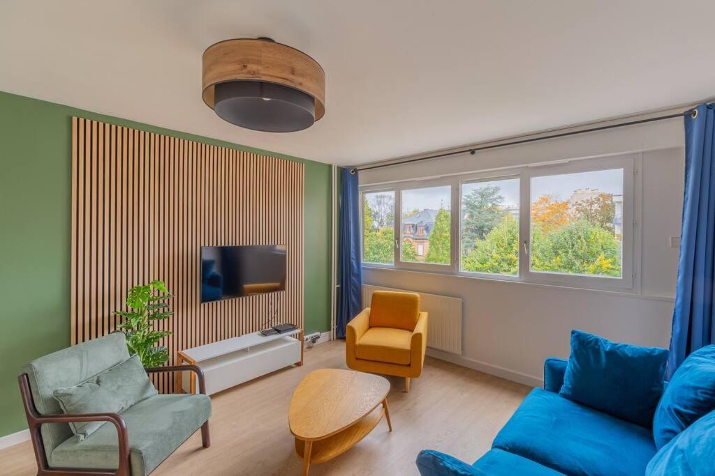 uma sala de estar com um sofá azul e uma cadeira em Le club green - appt 45 m2 - 4P - parking em Metz