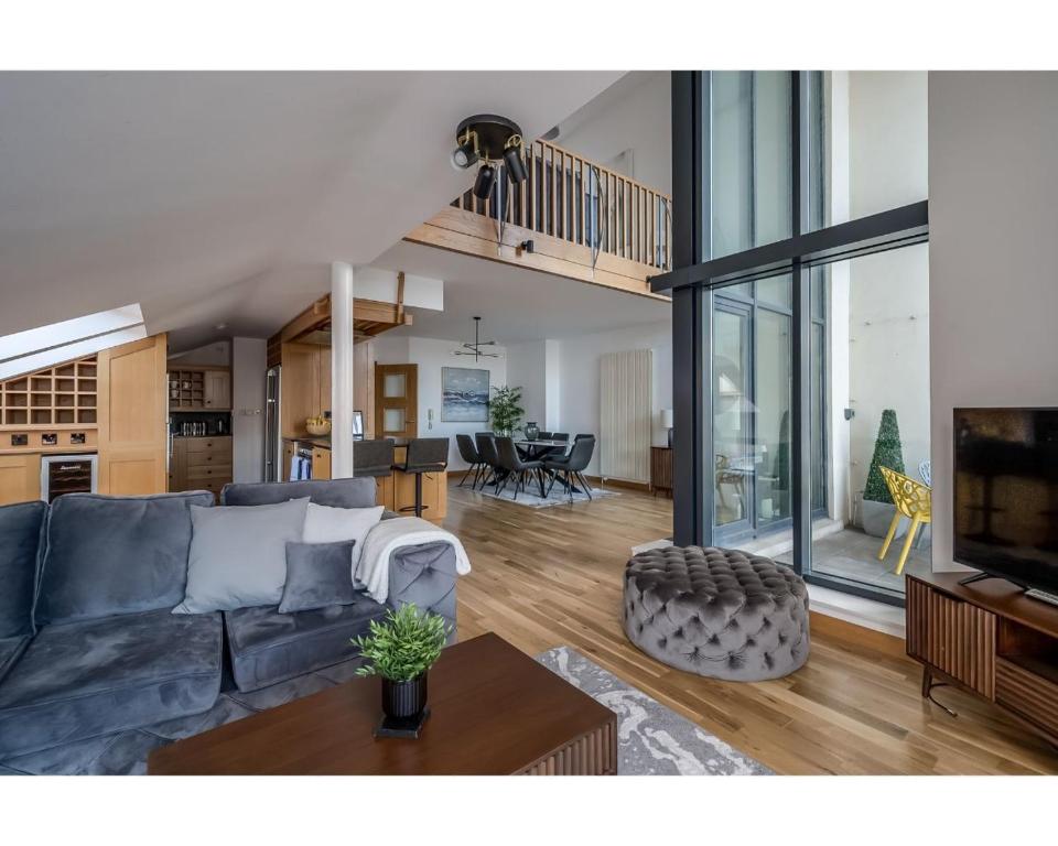 a living room with a blue couch and a table at Central Belfast Apartments Pottinger's Quay in Belfast