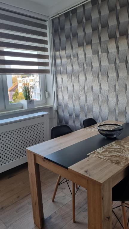 a table and chairs in a room with a window at Apartman Lumi in Čakovec