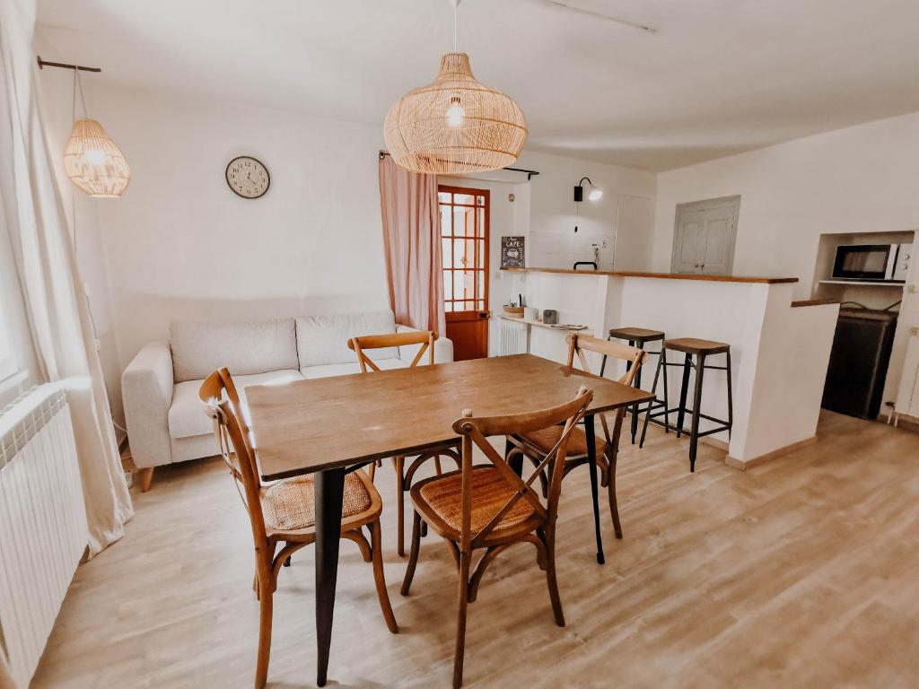 een keuken en eetkamer met een houten tafel en stoelen bij La Source in Oppedette
