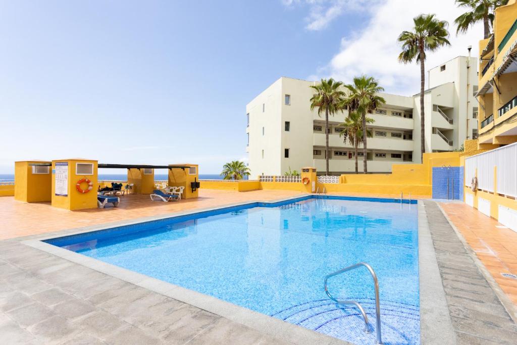 a swimming pool in the middle of a building at Playa La Arena with pool and privat parking in Puerto de Santiago