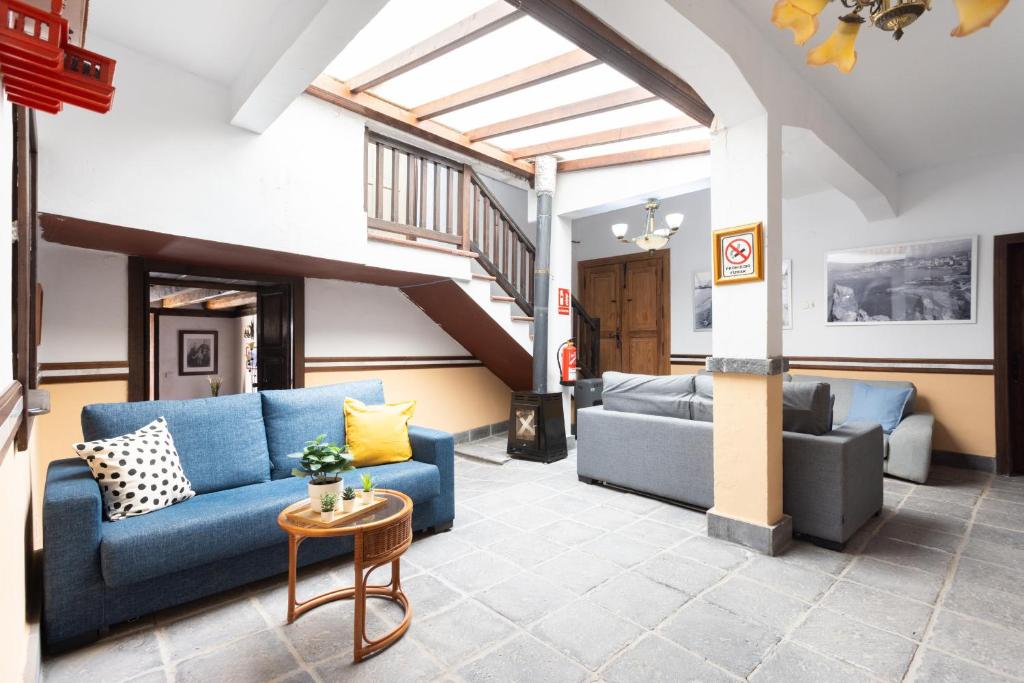 salon z niebieskimi kanapami i schodami w obiekcie Casa Argelia w mieście Vilaflor
