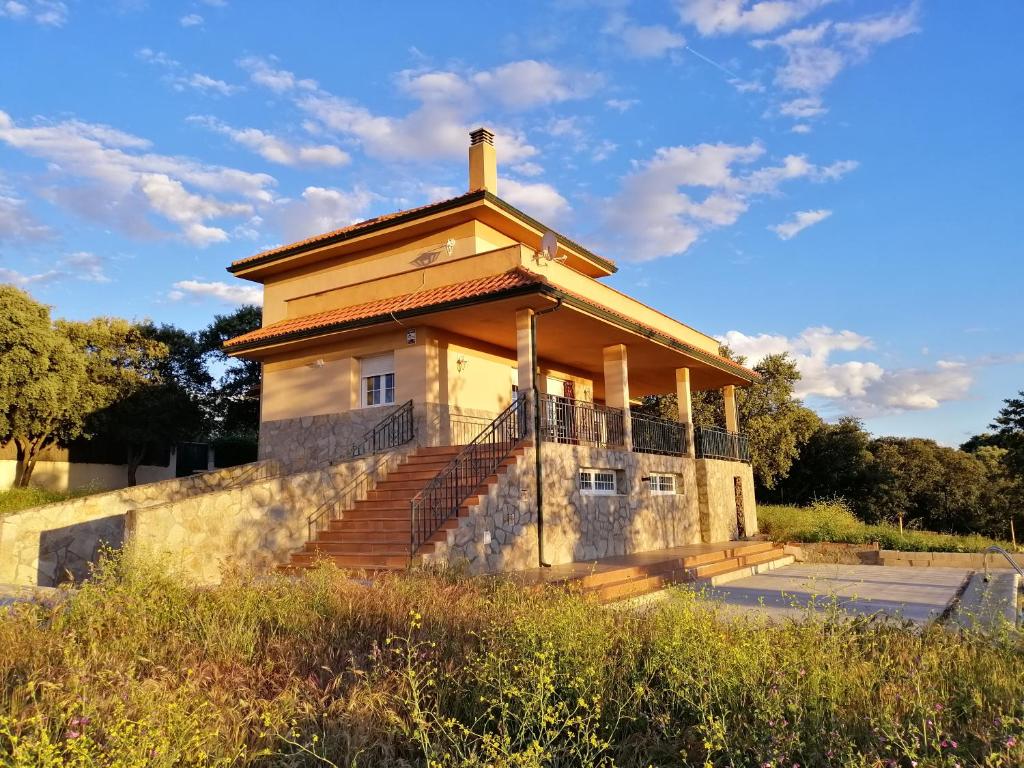 un pequeño edificio con una escalera en un campo en Shivanda, Habitaciones en Centro de Bienestar en la Naturaleza, en Pioz