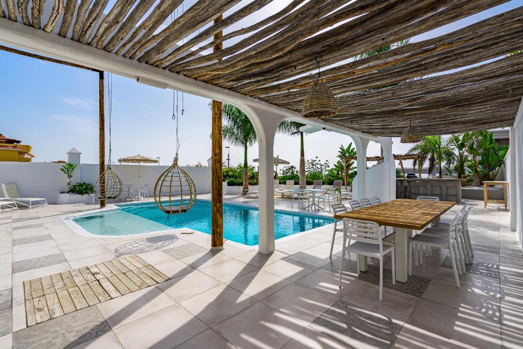 プエルト・デ・サンティアゴにあるVILLA8のパティオ(テーブル、椅子付)、プールが備わります。