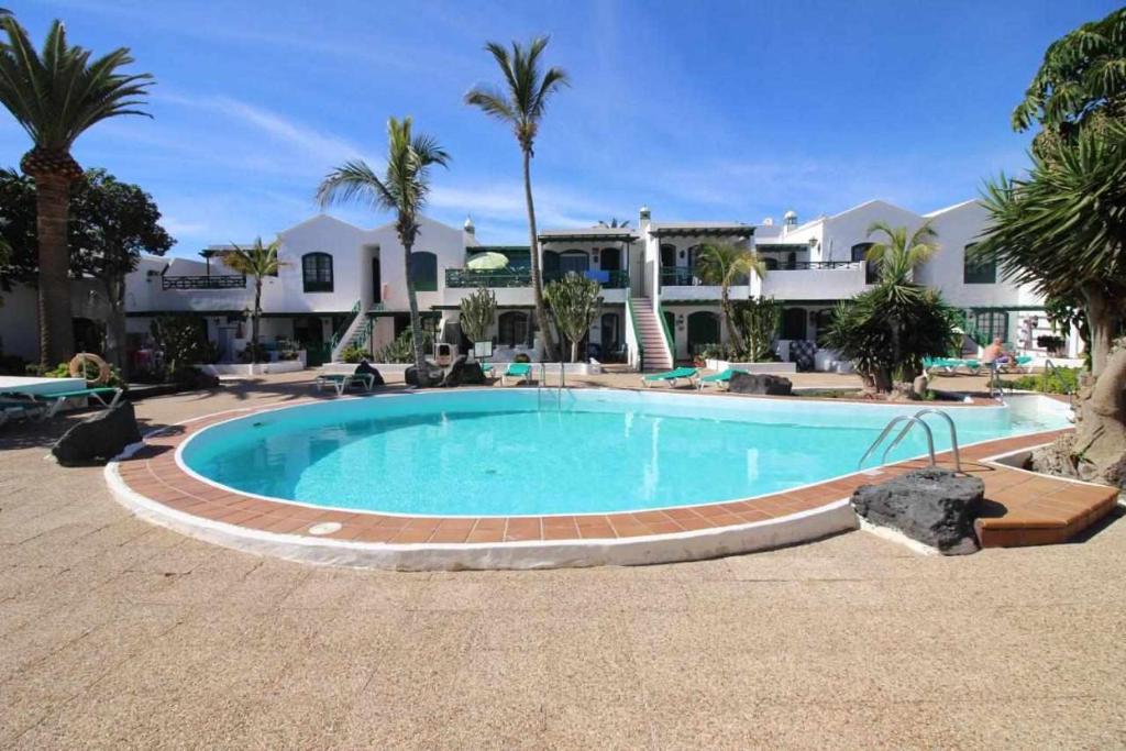 a swimming pool in front of a resort at Nautic Apartment in Puerto del Carmen in Tías