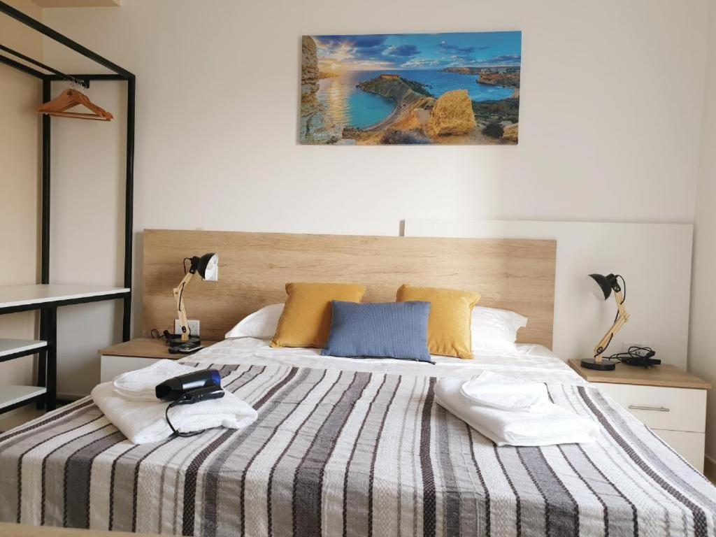a bedroom with a large bed with a striped blanket at Hammock Vibes Town House in Sliema