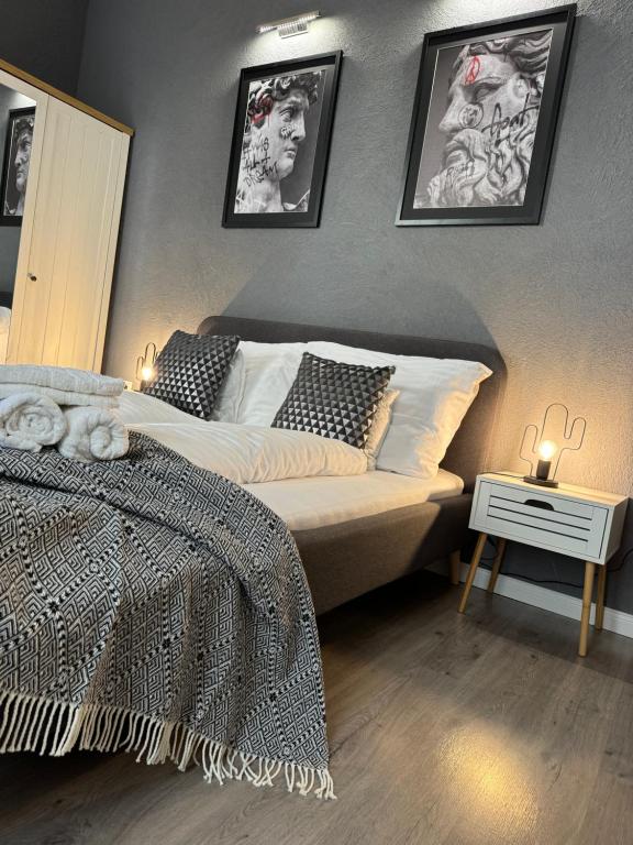 a bedroom with a bed and two pictures on the wall at Svatého Pasáž BOUTIQUE Apartments with free parking in Trnava