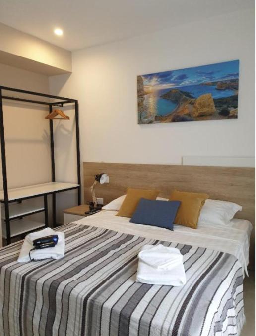 a bedroom with a bed with two towels on it at Hammock Vibes Town House in Sliema