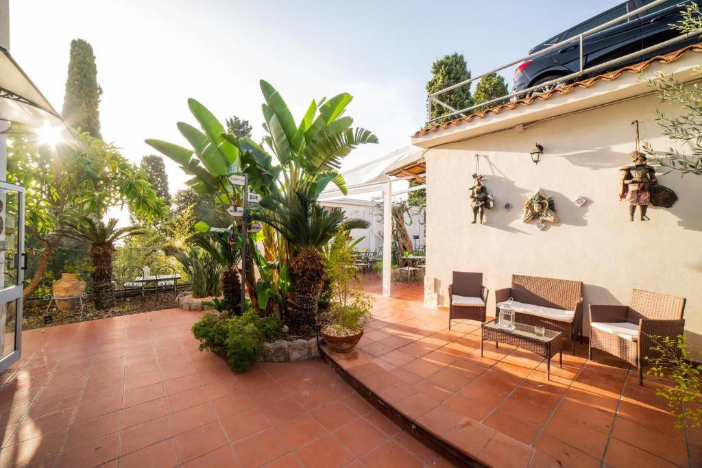 a patio with a table and chairs on a house at Taormina Garden Hotel in Taormina