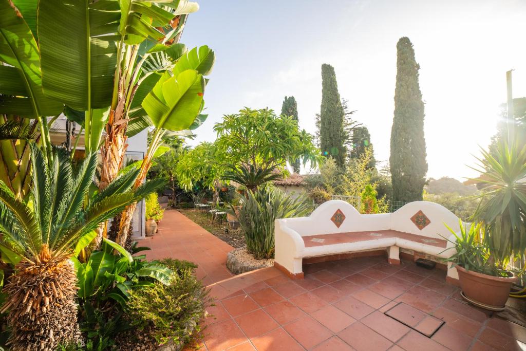 a garden with a white couch sitting on a patio at Taormina Garden Hotel in Taormina