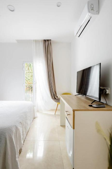 a hotel room with a bed and a television at Hammock Vibes Town House in Sliema