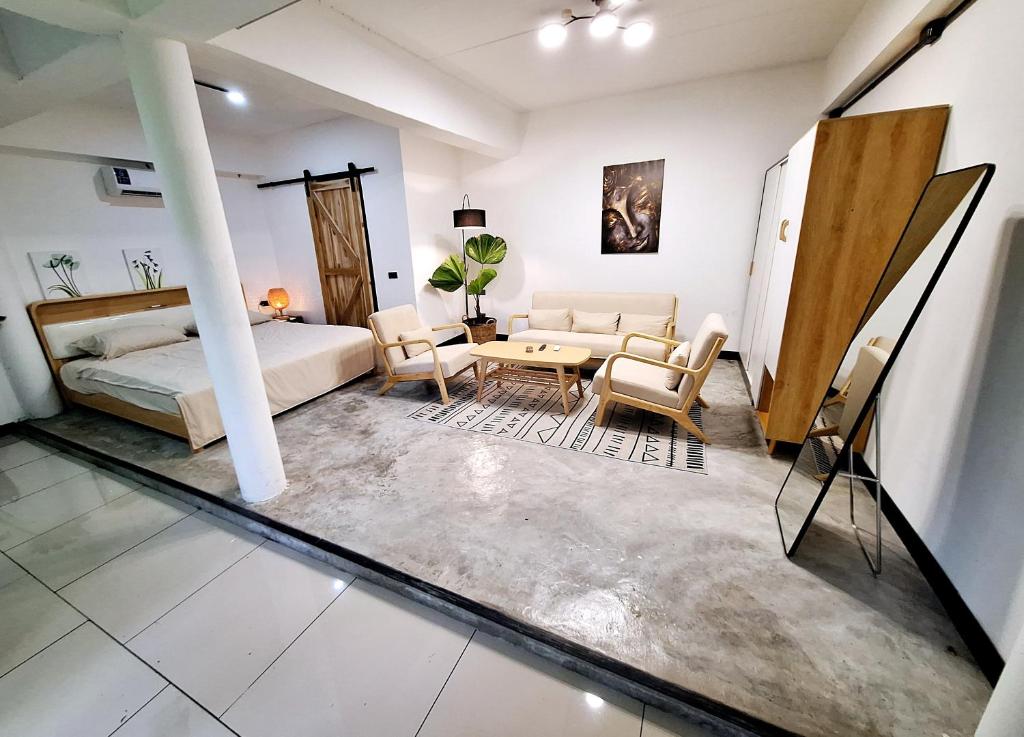- une chambre avec un lit, une table et des chaises dans l'établissement Bali-style studio apartment, à Ban Madua Wan