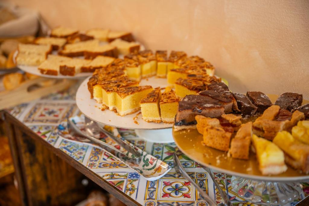 three plates of food on a table with desserts at Taormina Garden Hotel in Taormina