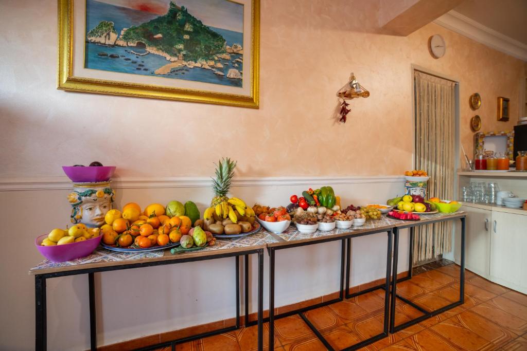 a table filled with fruits and vegetables in a room at Taormina Garden Hotel in Taormina